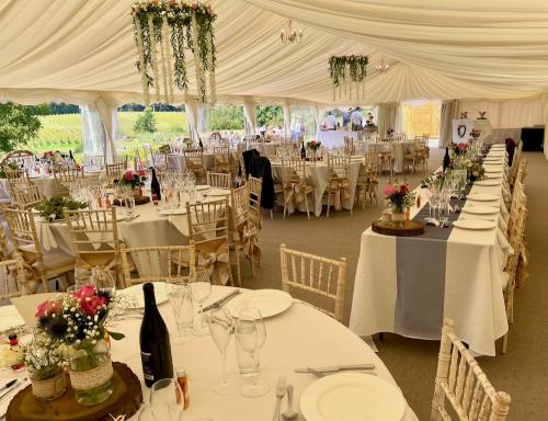 Inside marquee showing tables all dressed and ready for the wedding guests, Bluebell Vineyards, Uckfield, East Sussex.