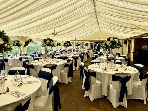 Fully dressed tables inside wedding marquee 