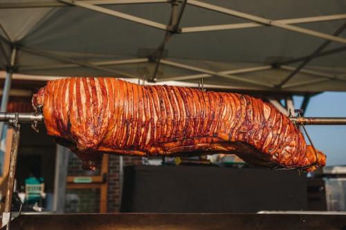 Sussex hog roast raised out of the roasting machine with golden crispy crackling.