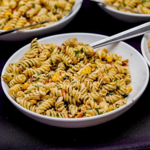 Fusilli pasta salad with spinach, sun dried tomatoes, pesto, sweet corn and Parmesan 