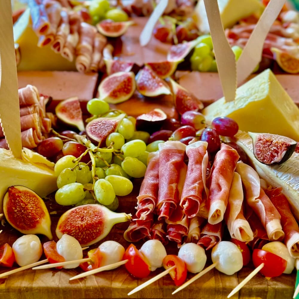 Charcuterie and cheeseboards with rolled proscuitto, figs, mozzarella, cheddar, brie and grapes