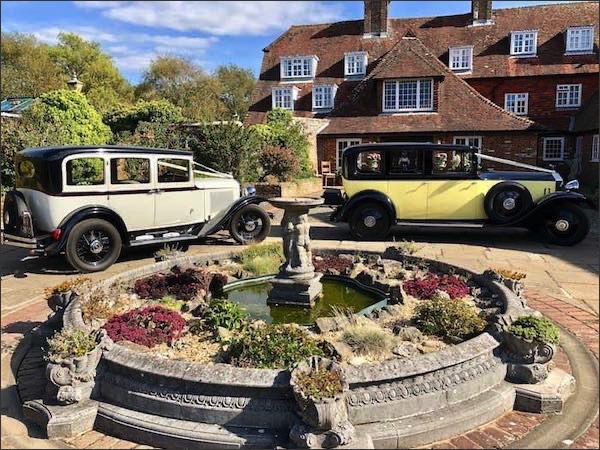 Outside Milwards House, Laughton, East Sussex with two wedding cars